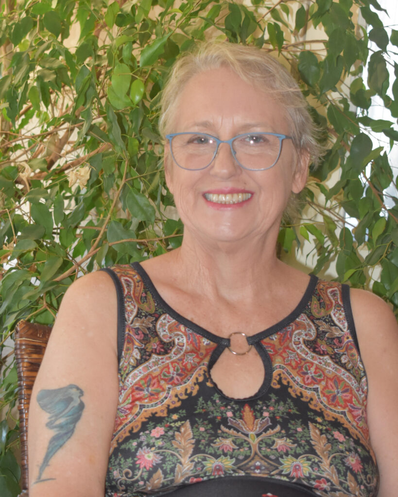 portrait of a woman smiling in front of a ficus tree